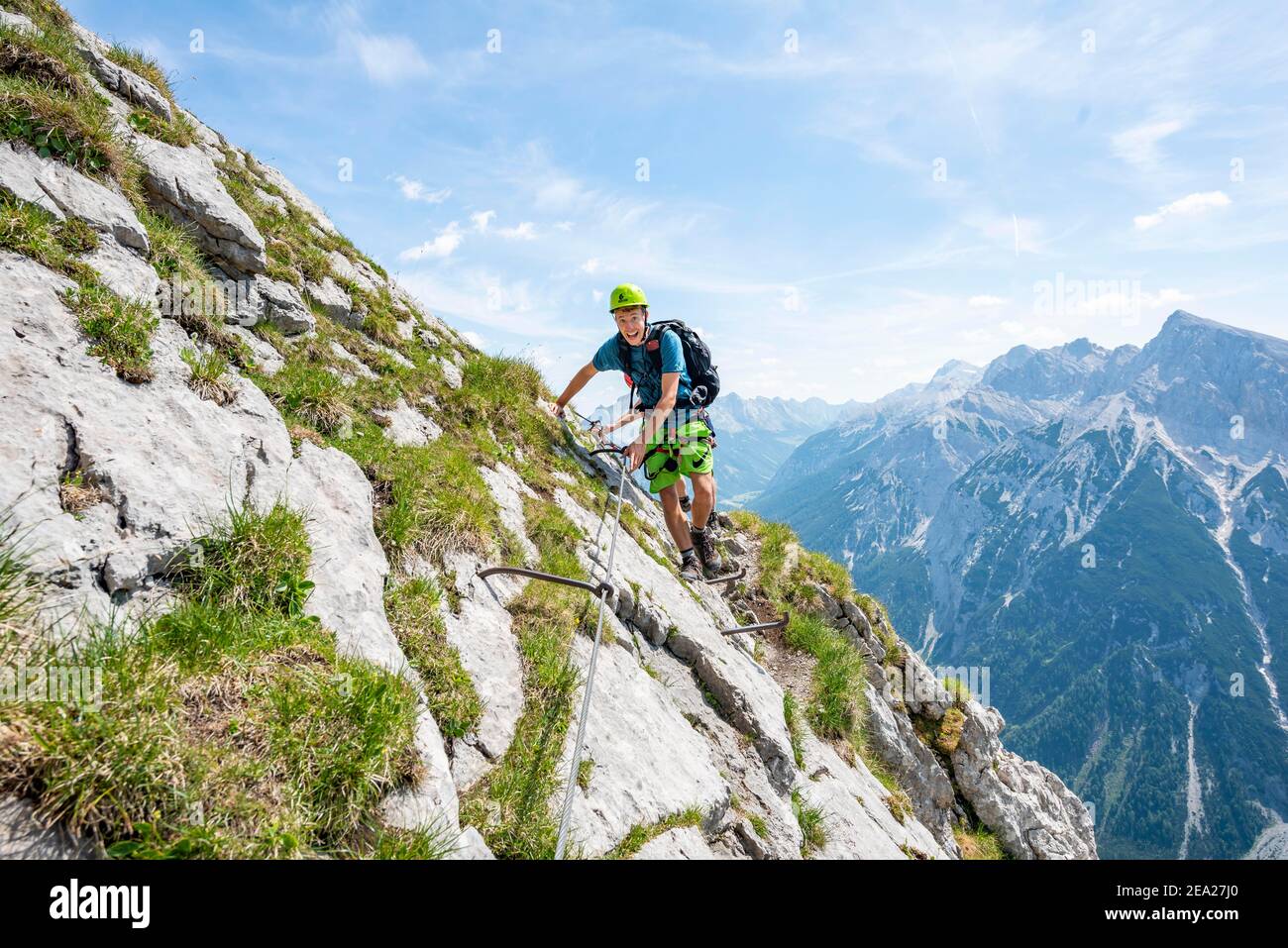 Alpinista su una sicura via ferrata, Mittenwalder Hoehenweg, vista del panorama montano, Karwendel Montagne, Mittenwald, Baviera, Germania Foto Stock