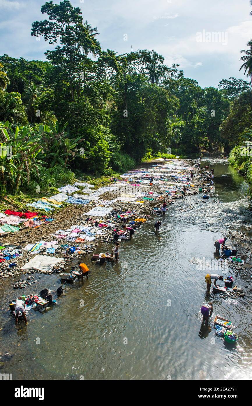 Le donne lavano i loro vestiti in un fiume alla costa orientale di Sao Tomé, Sao Tomé e Principe, Oceano Atlantico Foto Stock