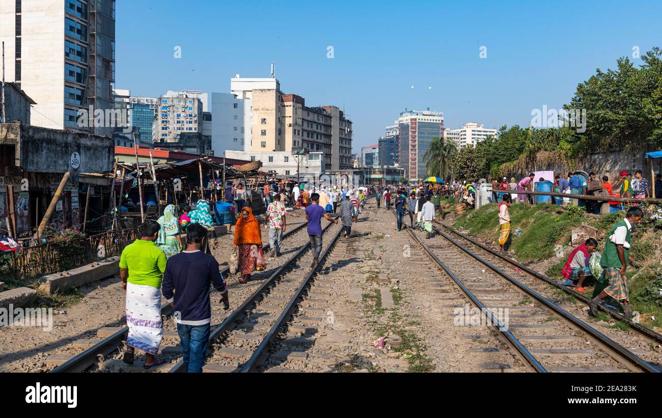 Venditori ambulanti sulle piste ferroviarie che attraversano Kawran Bazar, Dhaka, Bangladesh Foto Stock