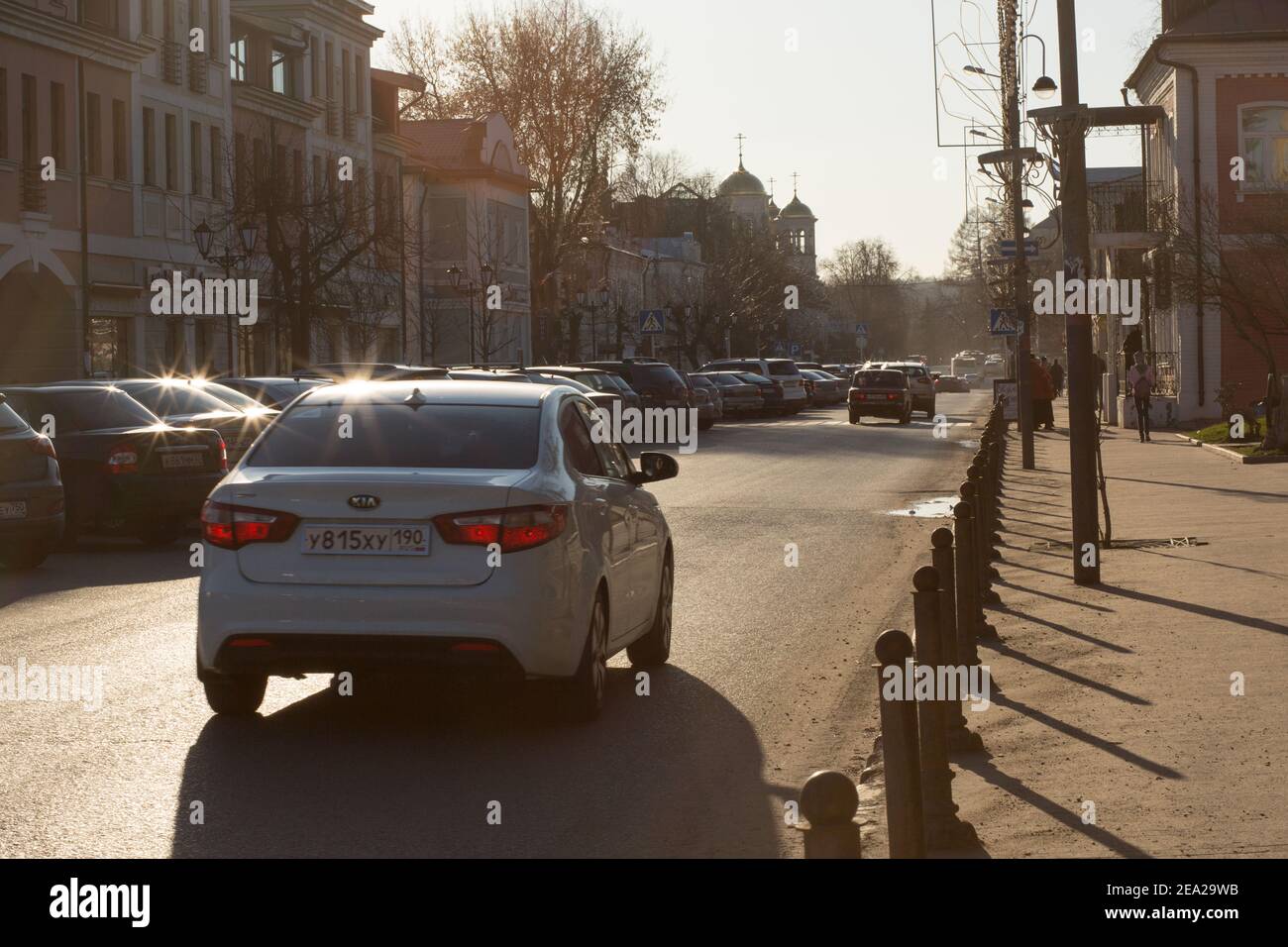 Zvenigorod, Russia - 04 16, 2019: Via Moskovskaya centrale nella città di Zvenigorod di Russia al tramonto. Strada con auto in controluce tramonto Foto Stock