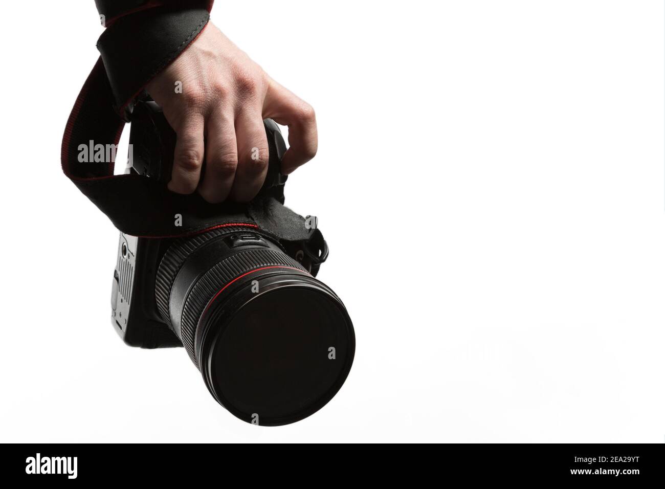 Un uomo con un anello sul dito che tiene in mano una fotocamera DSLR primo piano. Isolato su sfondo bianco. Studio . Fotografia concettuale, corsi fotografici Foto Stock