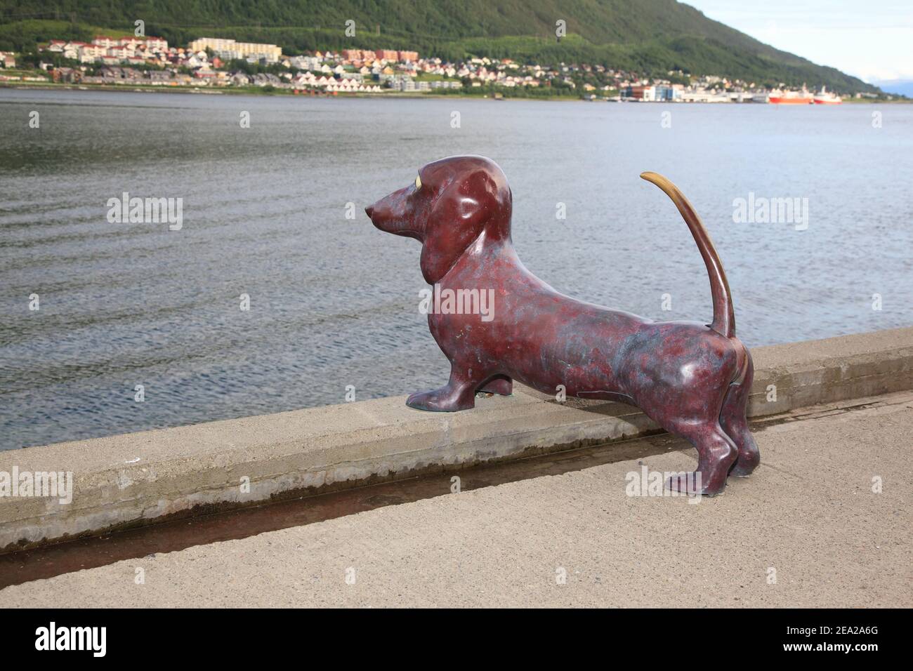 TROMSO, NORVEGIA - LUGLIO 27 2012: Divertente monumento a un cane dachshund in attesa del proprietario vicino al mare nella città settentrionale di Tromso in Norvegia. Fidelizzazione co Foto Stock