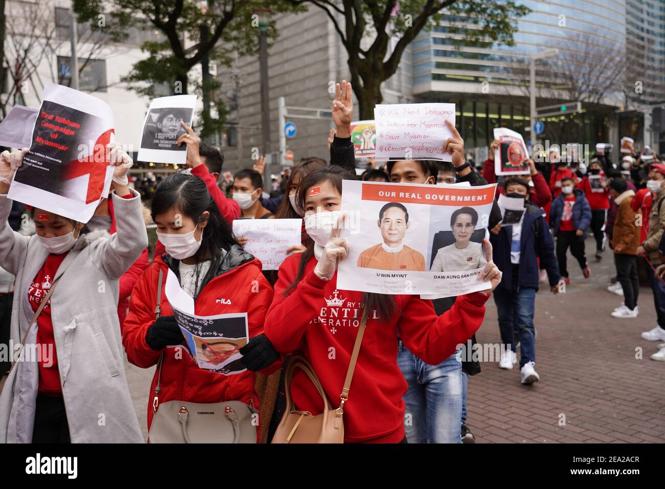 I manifestanti che indossano maschere facciali marciano per le strade mentre trasportano ritratti di Aung San Suu Kyi durante una protesta contro un colpo di stato militare nel loro paese.centinaia di residenti del Myanmar in Giappone scesi per le strade in una protesta che chiede il rilascio del leader della Lega nazionale per la democrazia (NLD) Aung San Suu Kyi e altri politici detenuti dai militari. Foto Stock
