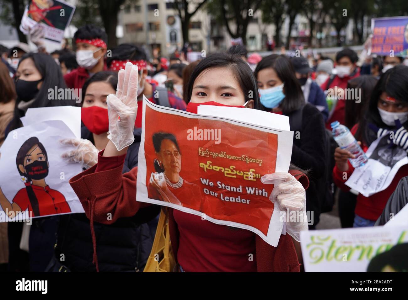 Un manifestante che indossa guanti e tiene un cartello solleva un saluto a tre dita durante una protesta contro un colpo di stato militare nel loro paese.centinaia di residenti in Myanmar in Giappone scesi in piazza in una protesta che chiede il rilascio del leader della Lega nazionale per la democrazia (NLD) Aung San Suu Kyi e altri politici detenuti dai militari. Foto Stock