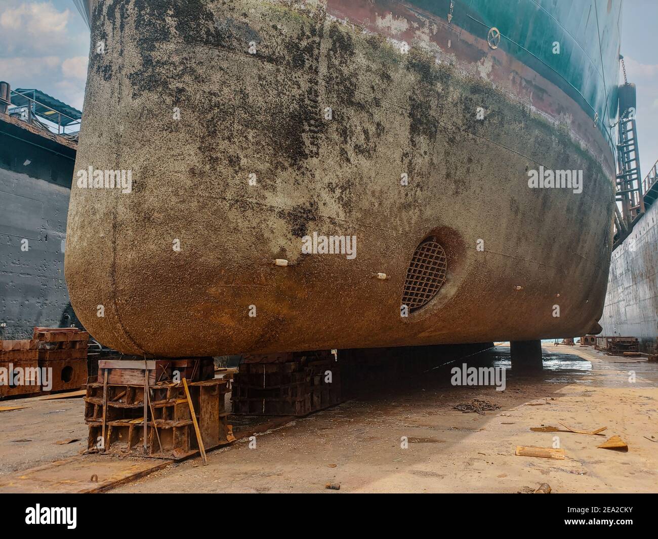 Vista industria - Ocean Vessel nel bacino asciutto in cantiere. Vecchia nave arrugginita in riparazione Foto Stock
