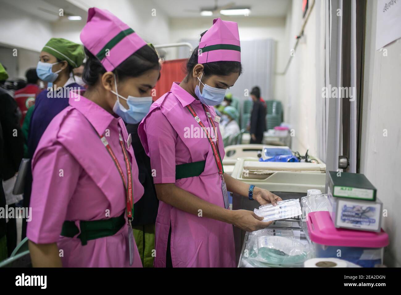 Un infermiere che indossa una maschera per il viso contiene siringhe da utilizzare per la somministrazione del vaccino durante il ciclo a secco del vaccino COVID-19 presso un Medical College. Il Bangladesh ha lanciato la sua campagna per il vaccino Covid-19 a livello nazionale tra le tiepide risposte dei cercatori di vaccini. Il Ministro della Sanità Zahid Maleque ha inaugurato la campagna in occasione di un evento virtuale presso la direzione Generale dei servizi sanitari (DGHS) di Dhaka, domenica mattina. Foto Stock