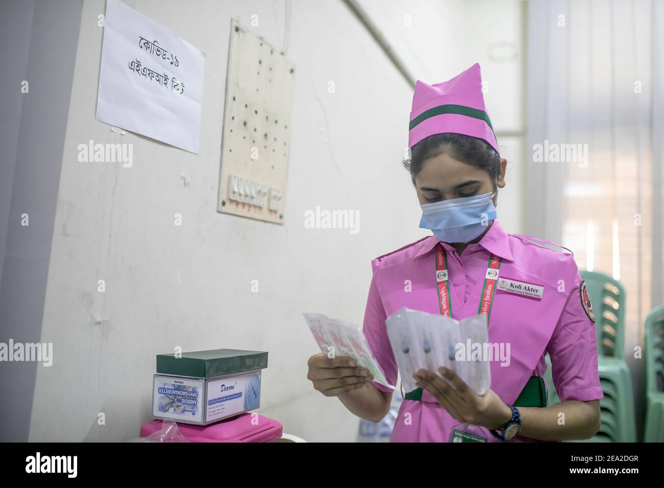 Un infermiere che indossa una maschera porta siringhe da usare nella somministrazione del vaccino durante il ciclo a secco del vaccino COVID-19 presso un Medical College. Il Bangladesh ha lanciato la sua campagna per il vaccino Covid-19 a livello nazionale tra le tiepide risposte dei cercatori di vaccini. Il Ministro della Sanità Zahid Maleque ha inaugurato la campagna in occasione di un evento virtuale presso la direzione Generale dei servizi sanitari (DGHS) di Dhaka, domenica mattina. Foto Stock