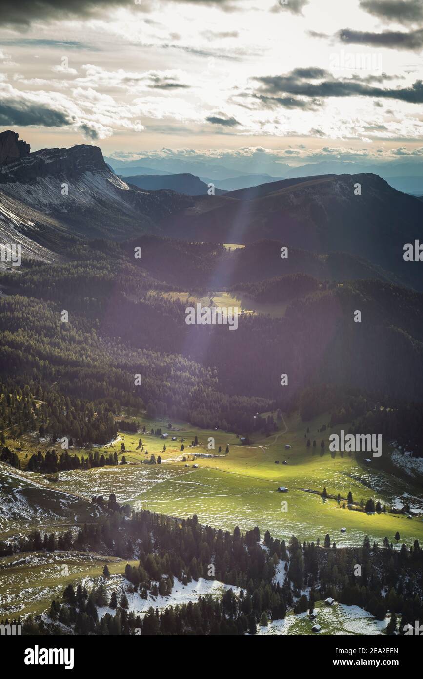 Il sole splende tra le nuvole su un paesaggio autunnale delle Dolomiti con Gamben alp, Geisler alp, Rasciesa e Seceda del gruppo Puez-Odle, Villnoess Foto Stock