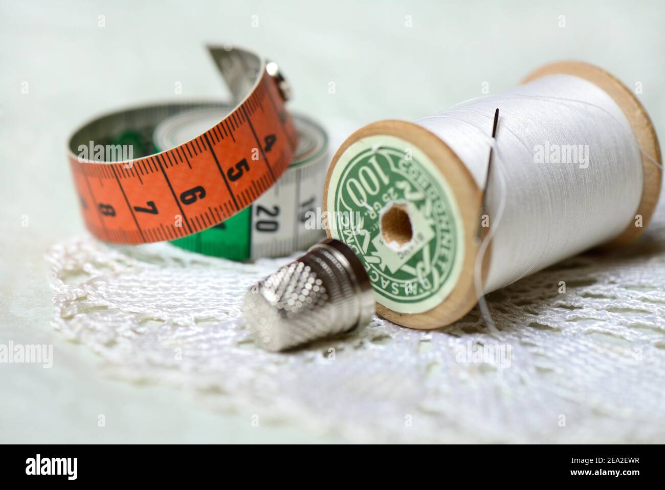 Rotolo di filo con ago da cucire, ditale e metro a nastro Foto Stock