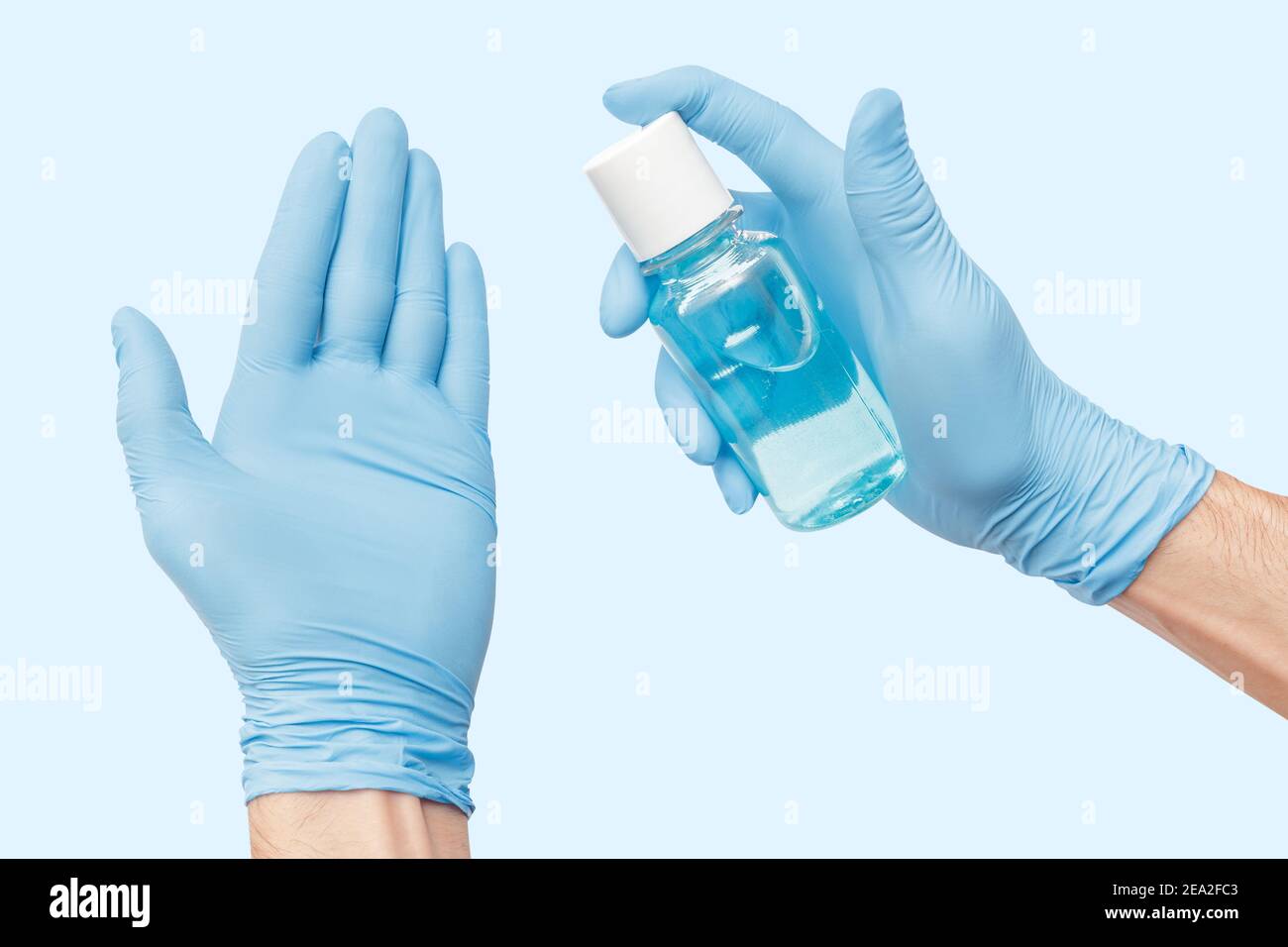 La mano isolata con guanti utilizza un disinfettante liquido a base di alcol che uccide la maggior parte dei tipi di microbi e virus. Concetto di Covid e germofobia Foto Stock