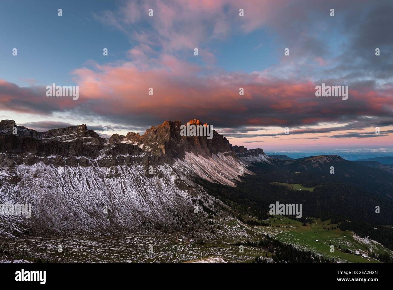 Nuvole, scogliere e le cime dei monti Puez-Odle al crepuscolo rosso all'alba sulle Dolomiti, sulla valle del Villnöß, sul Tirolo, Italia Foto Stock