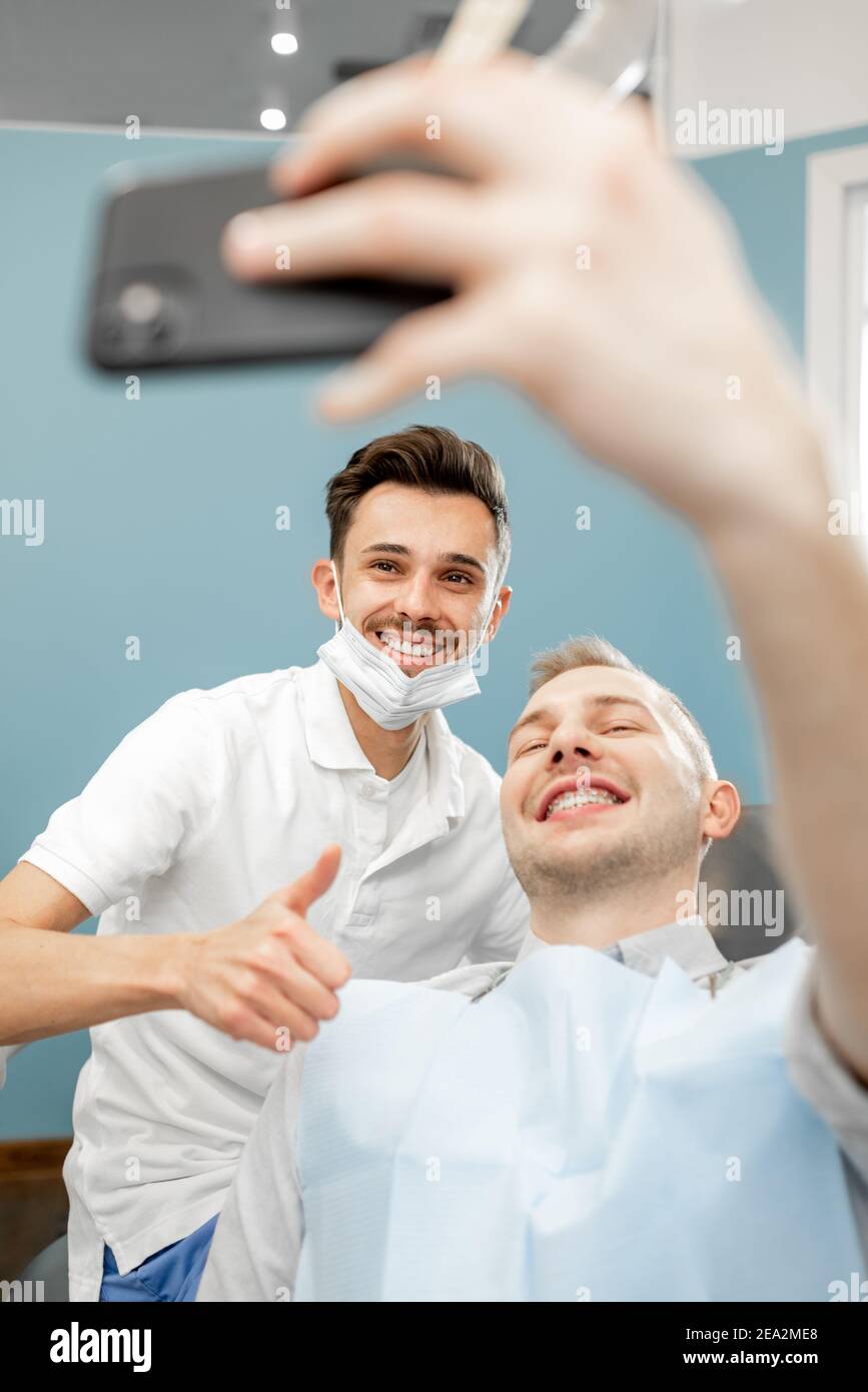 Paziente felice con un dentista presso l'ufficio odontoiatrico Foto Stock