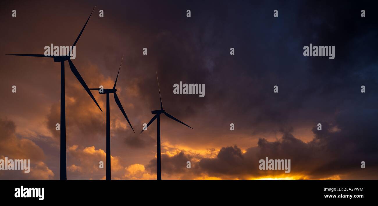 sagome delle turbine eoliche al tramonto Foto Stock
