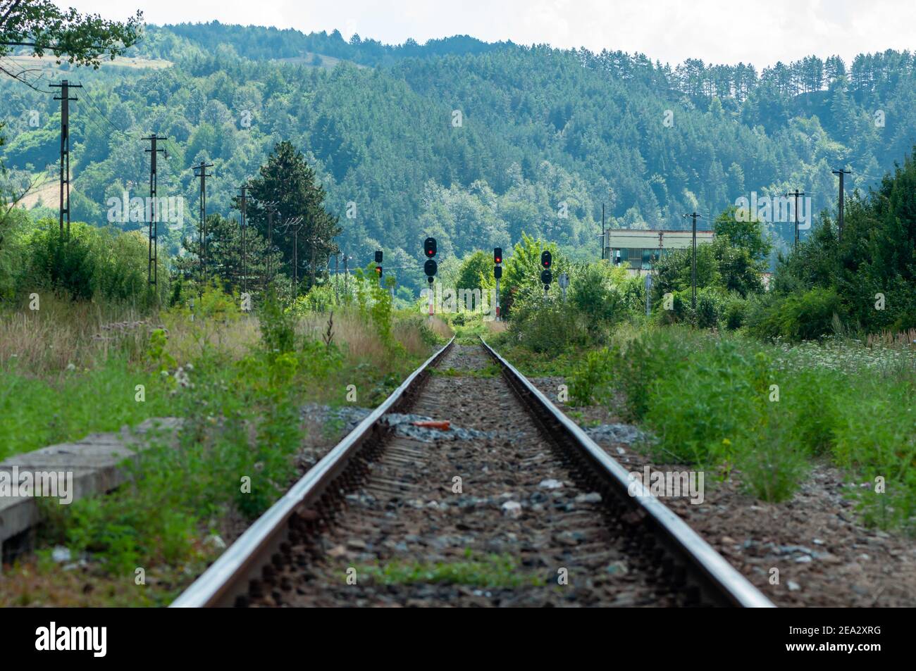 Una vista di una vecchia ferrovia. Segnali ferroviari. Un moutain e una foresta sullo sfondo. Foto Stock