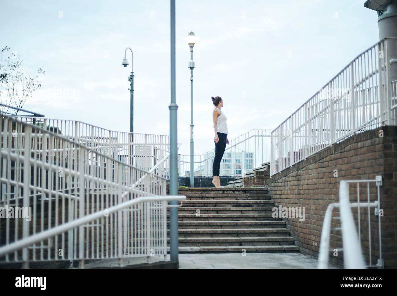 Vista posteriore della donna alta che guarda la vista, in piedi in verticale, dritta come un palo della lampada. Stile di vita all'aperto, concetto ricreativo. Londra, Regno Unito Foto Stock