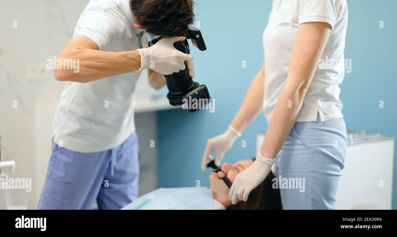 Dentista che fotografa il risultato del suo lavoro Foto Stock