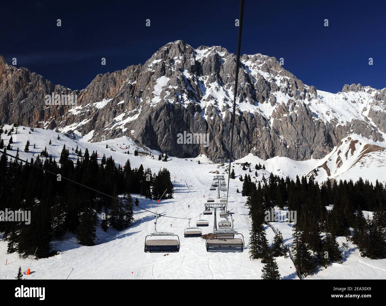 Comprensorio sciistico Ehrwalder Alm con vista sul Monte Zugpitze Austria Durante UNA seggiovia giro in UNA bella giornata invernale soleggiato Con un cielo blu chiaro Foto Stock