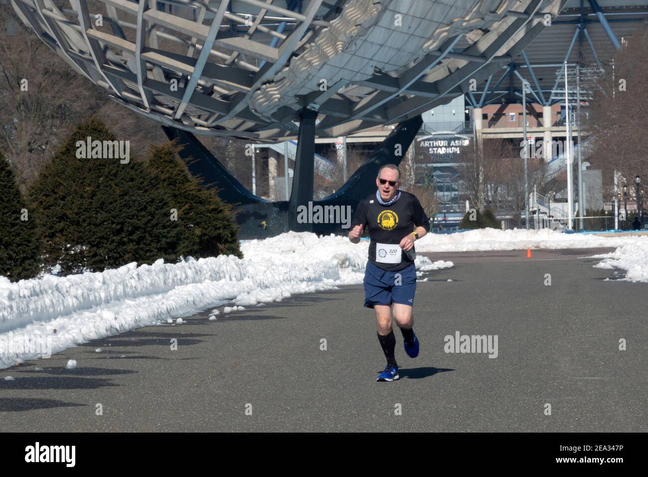 Un uomo di mezza età che corre nel NYC Winter Park Tour 4 miglia corsa a Flushing Meadows Corona Park a Queens, New York. Foto Stock