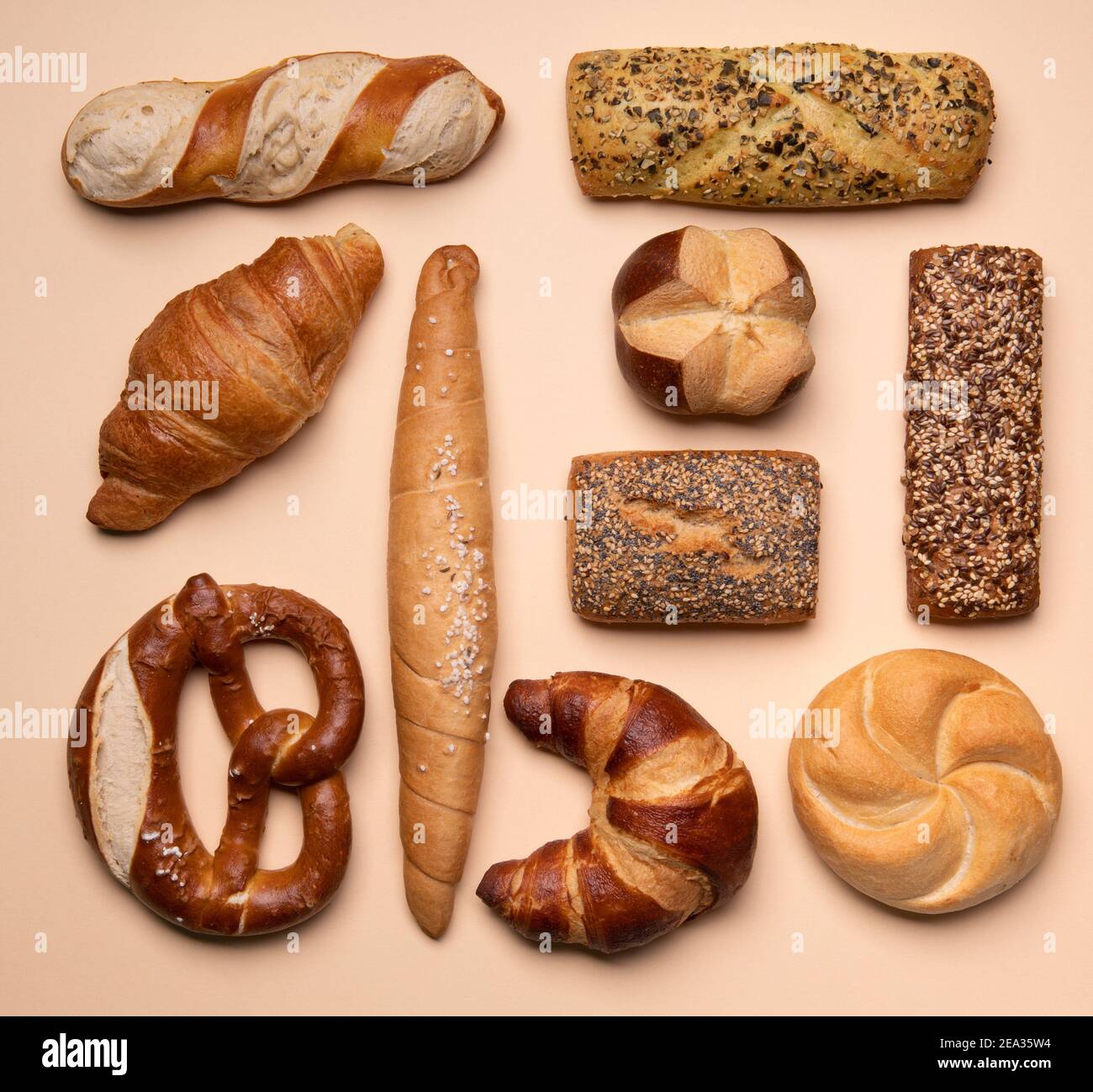 Diversi tipi di pasticceria concetto piatto. Su sfondo crema. Danese, croissant, pane pretzel. Foto Stock