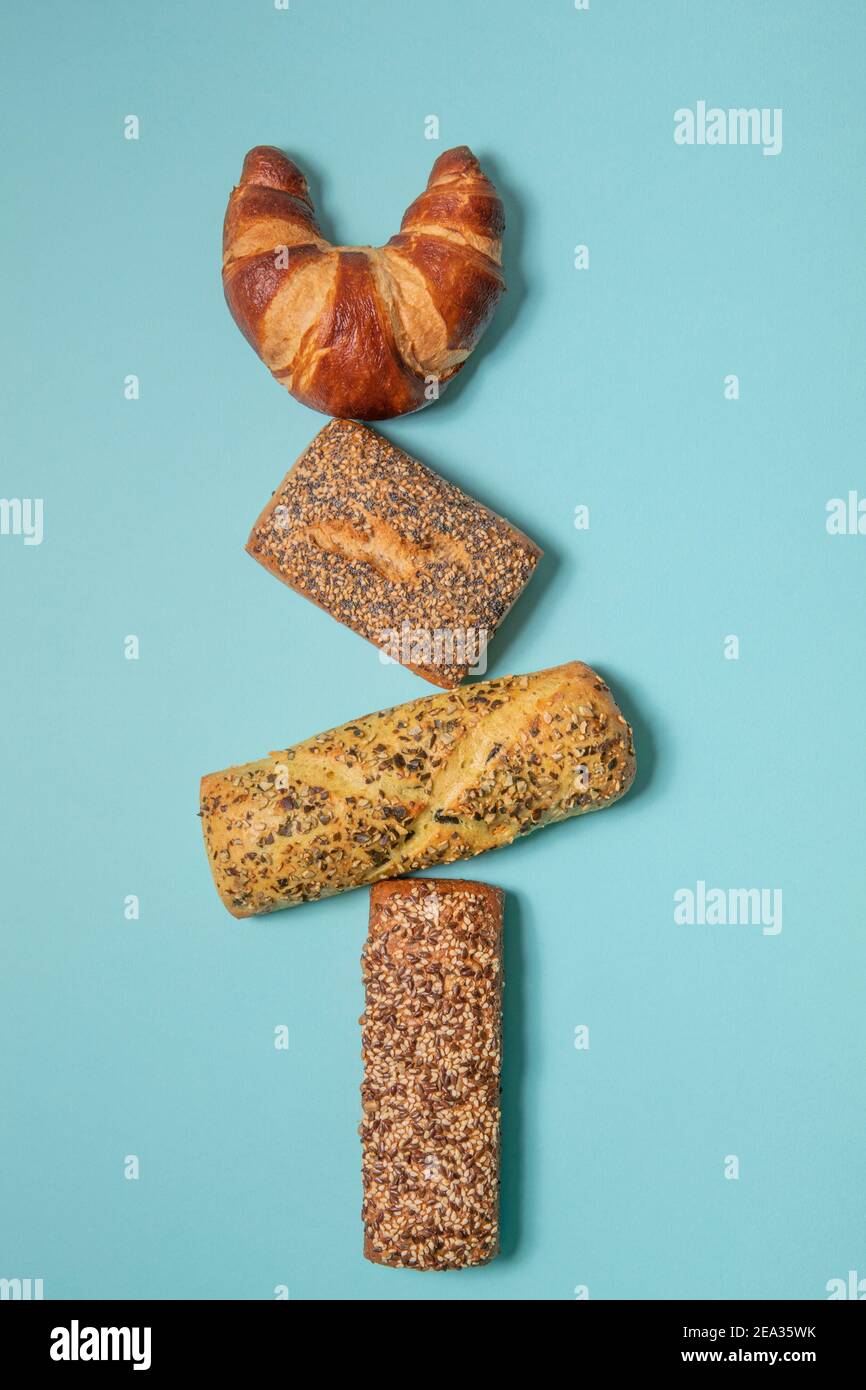 Diversi tipi di pasticcini, su sfondo blu, sono piatti. Danese, croissant, pane pretzel. Foto Stock