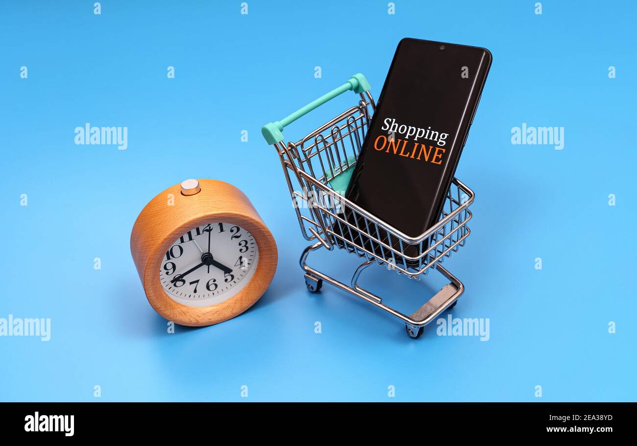 Carrello con smartphone e orologio. Concetto di shopping online. Foto Stock