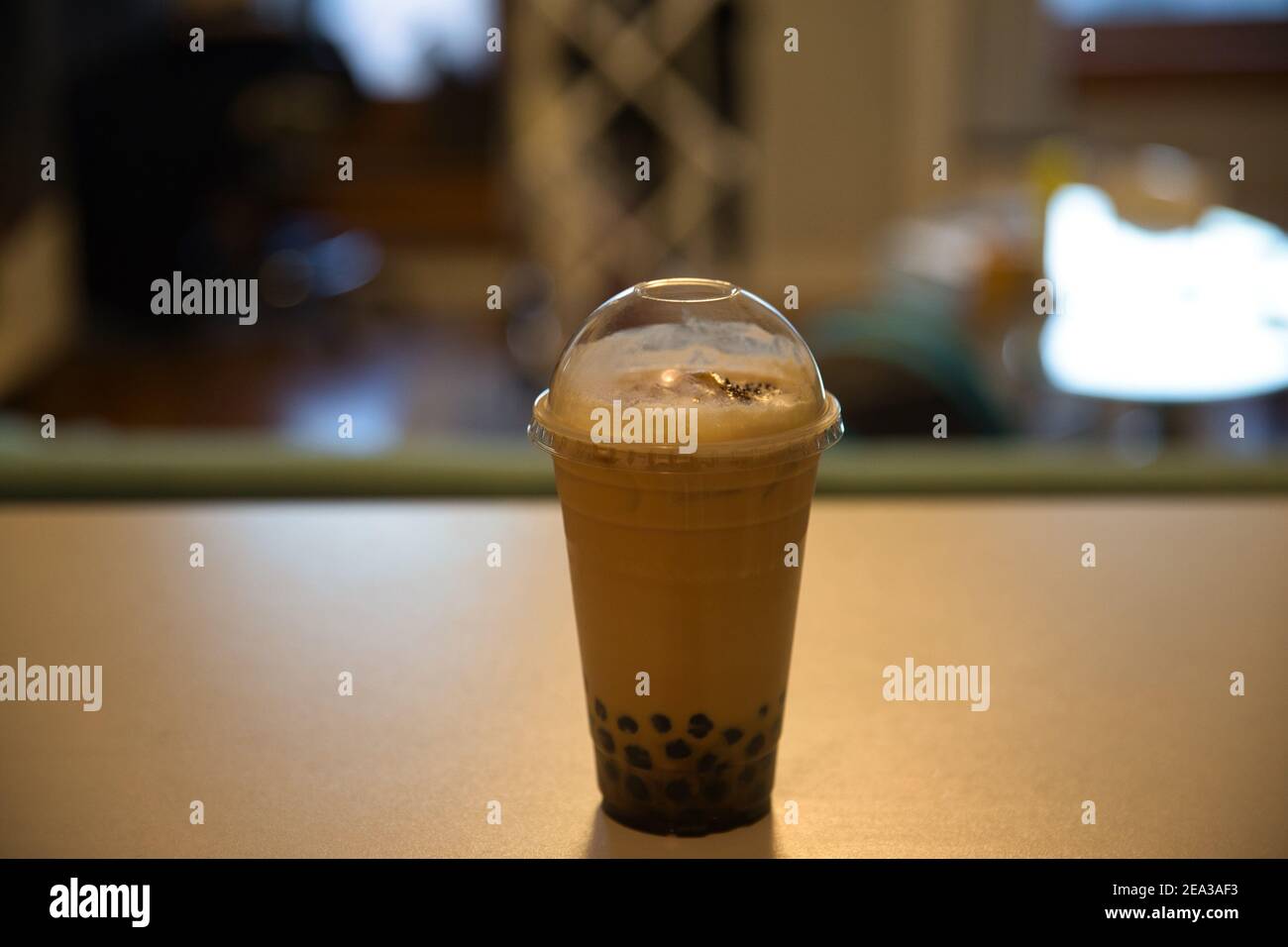 Tè al latte tailandese con zucchero di canna e tapioca su sfondo sfocato. Foto Stock
