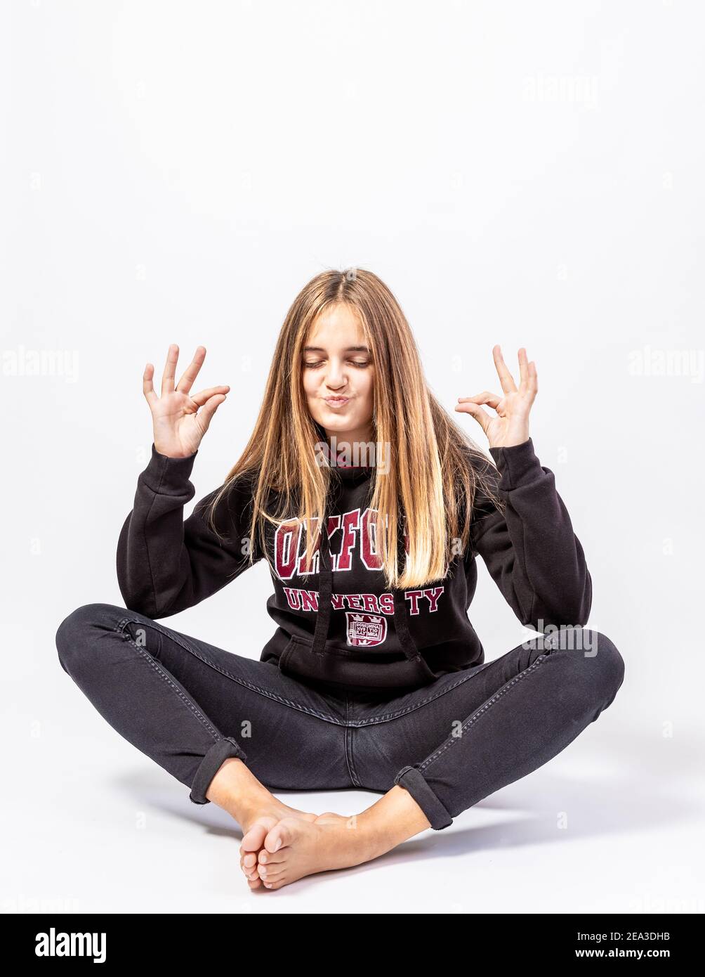 Giovane ragazza in posa orientale con espressione divertente e chiusa occhi Foto Stock