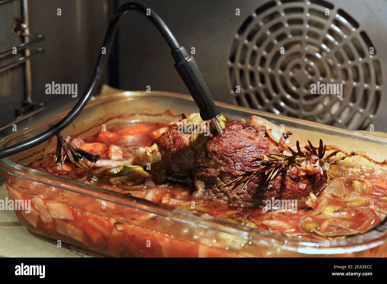 Primo piano di delizioso manzo arrosto con rosario e verdure nel forno con termometro Foto Stock