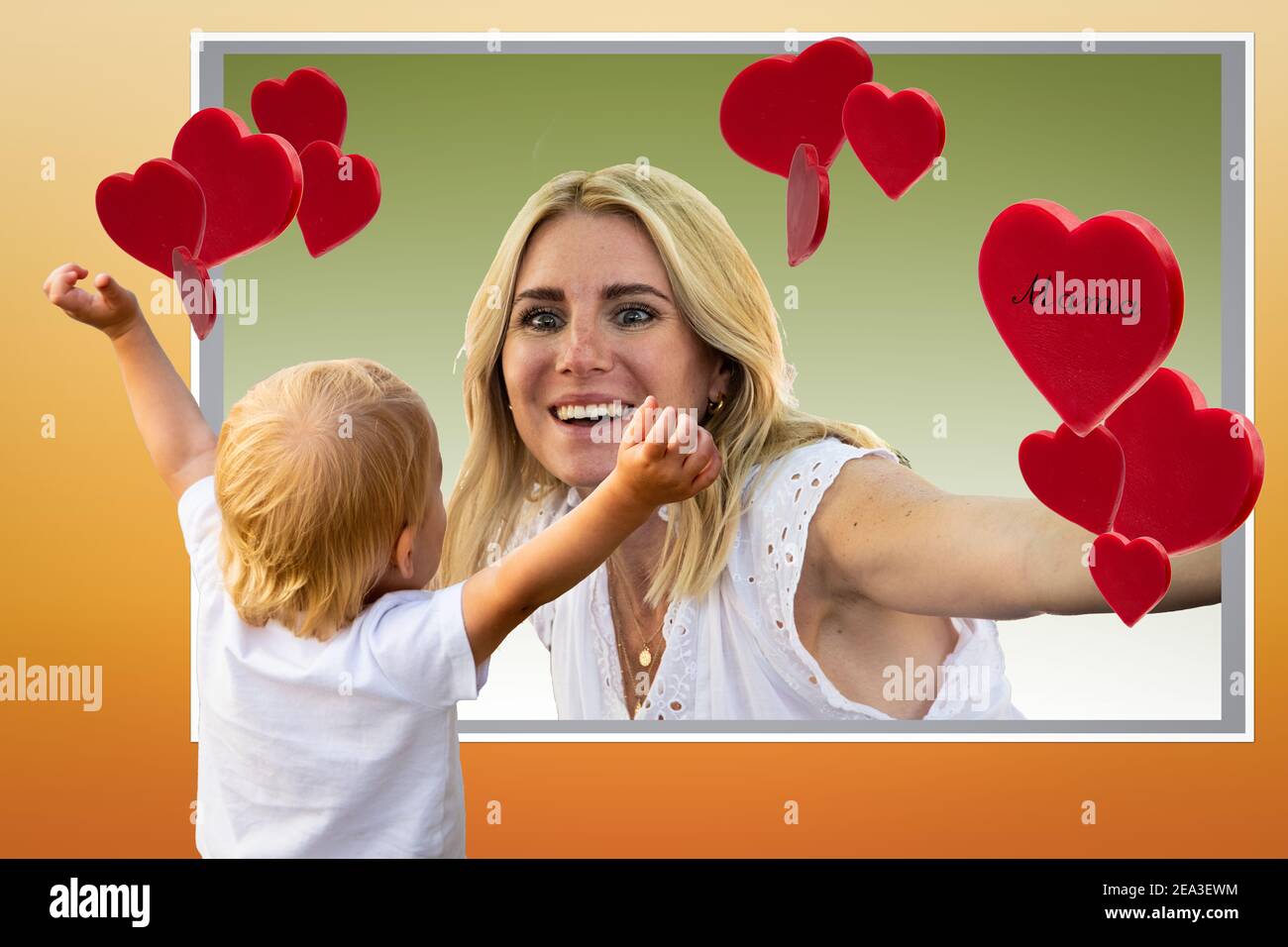 Bambino guardando una foto di sua madre con amore e gioia. Ha aperto le mani per abbracciare l'immagine. Foto Stock