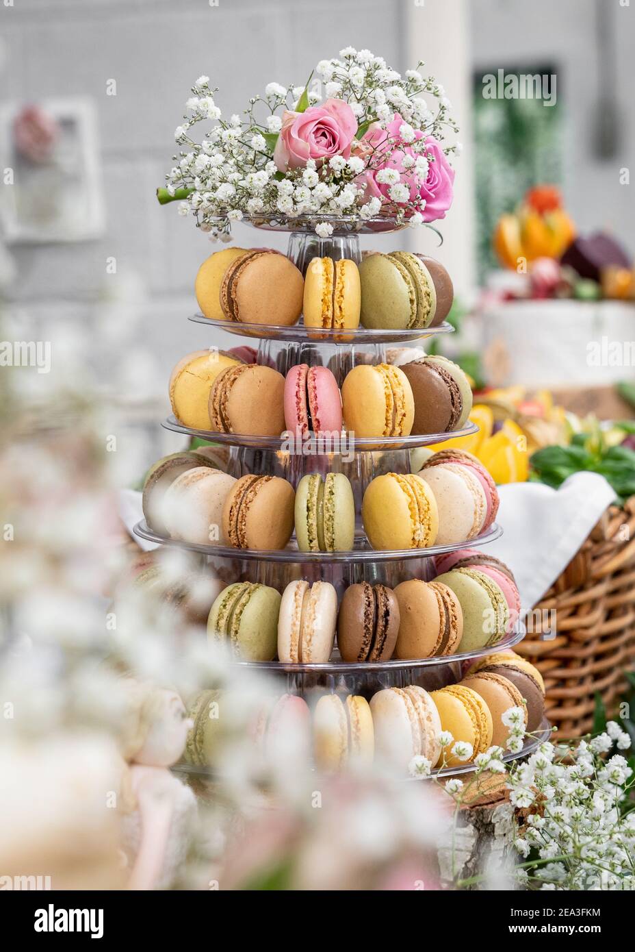 Orizzontale bella pasticceria torta macaron serie multi piano stand pieno di macaron tutti i colori sapori matrimonio reale con fiori e rose cioccolato rosa Foto Stock