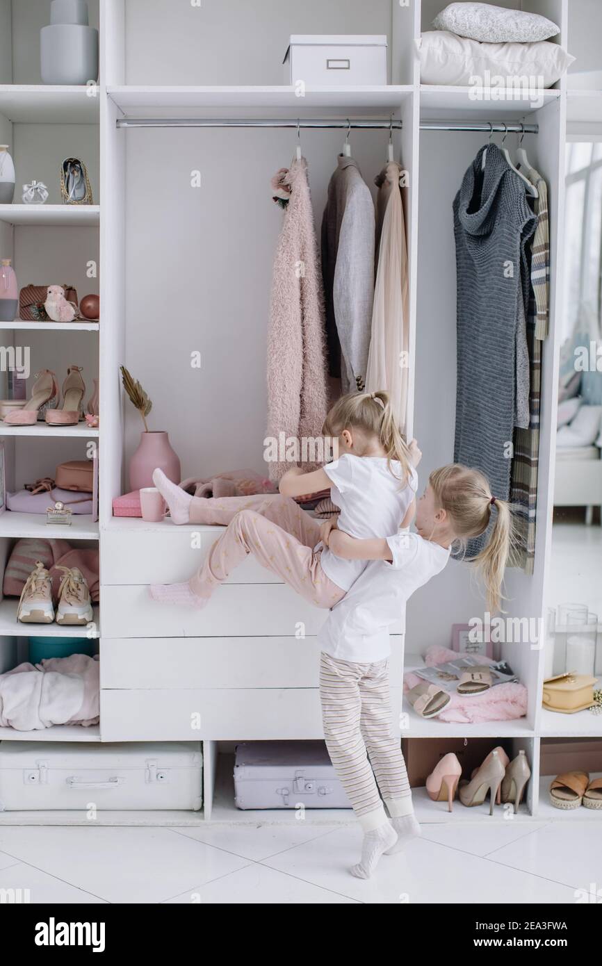 Le ragazze gemelle provano sulle cose nella stanza moderna di cabina della loro madre. Foto Stock
