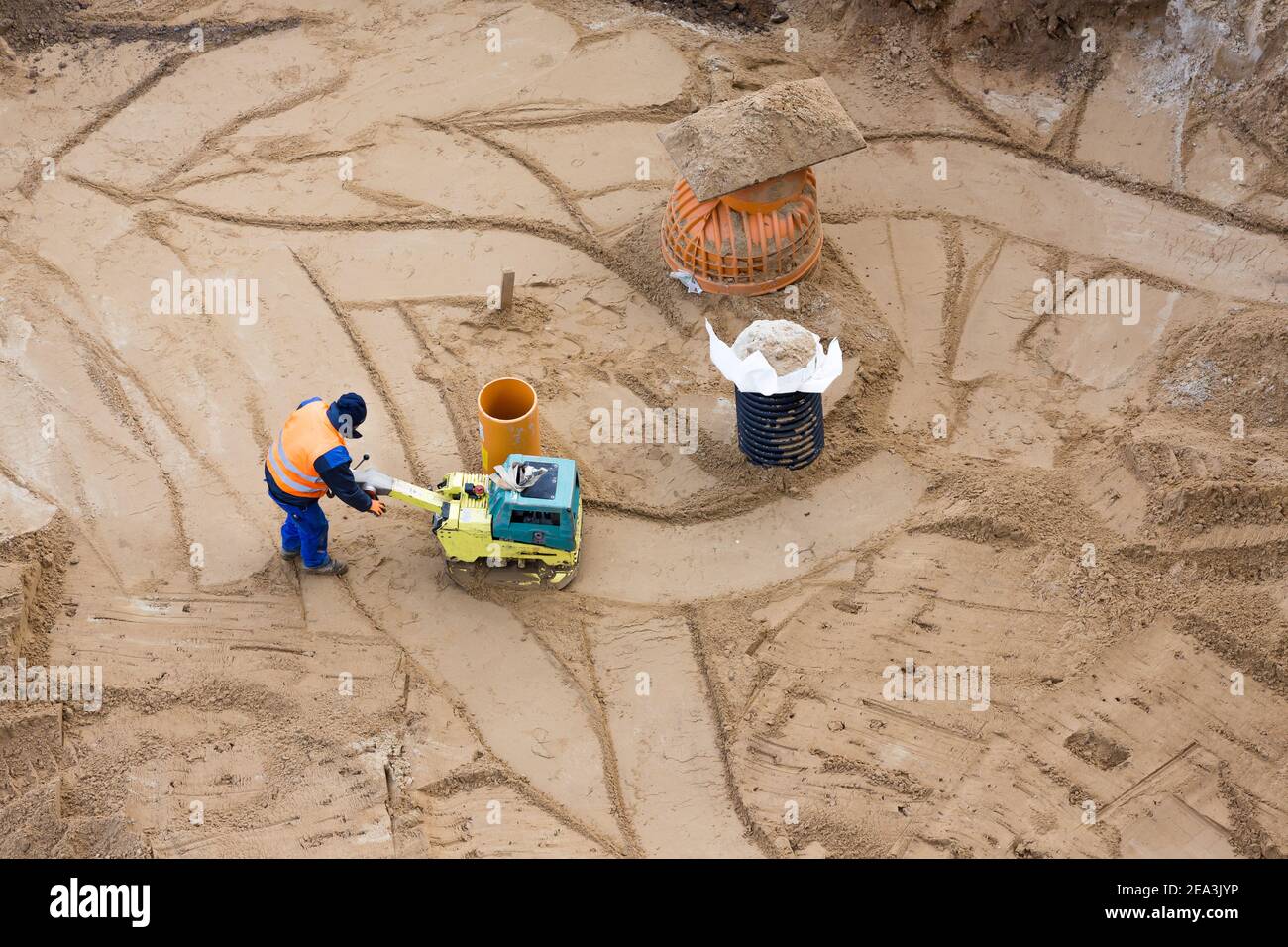vista aerea di un lavoratore con un compattatore in costruzione sito Foto Stock