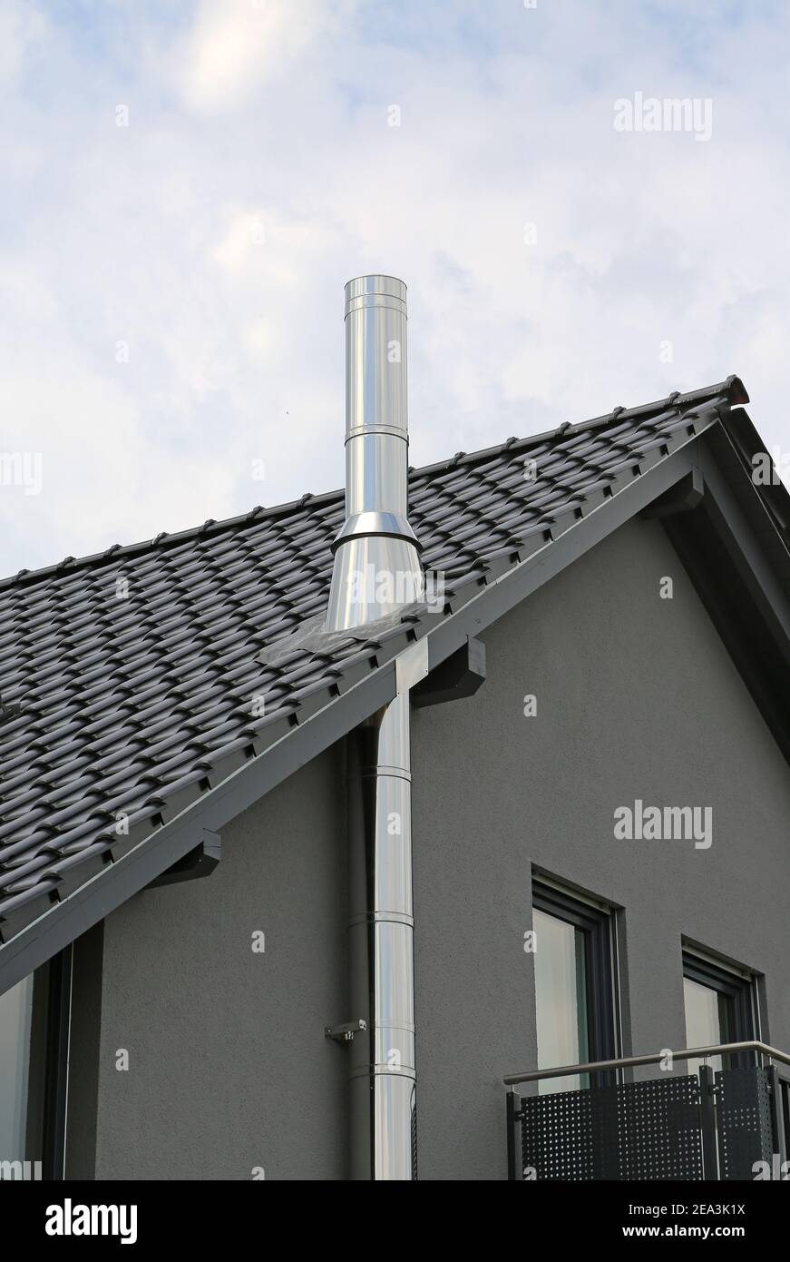 tubo di scarico in acciaio inox su casa distaccata in antracite Foto Stock