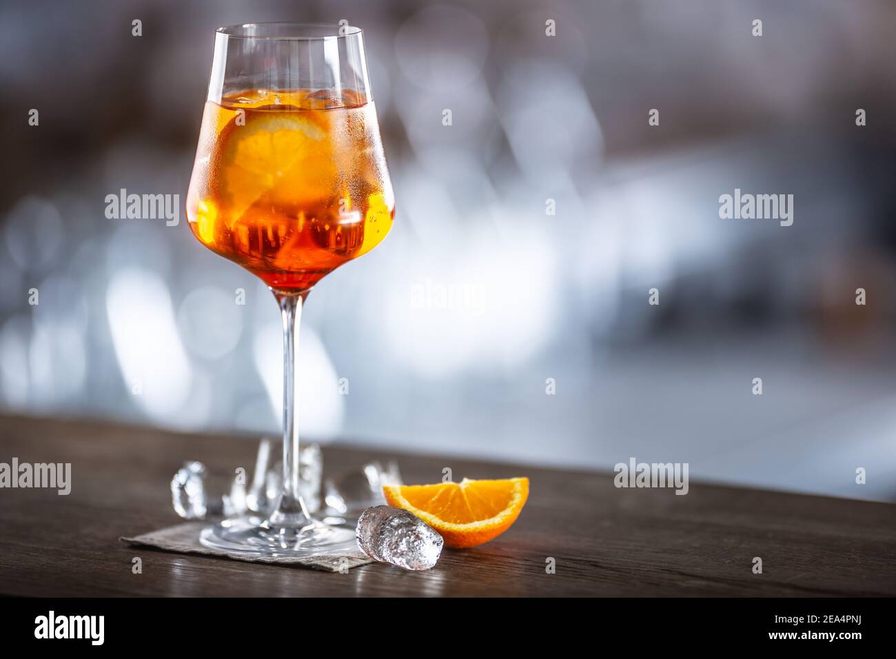 Tipica bevanda estiva aperol Spritz servita in bicchiere di vino con aperol, prosecco, soda e una fetta di arancia. Foto Stock