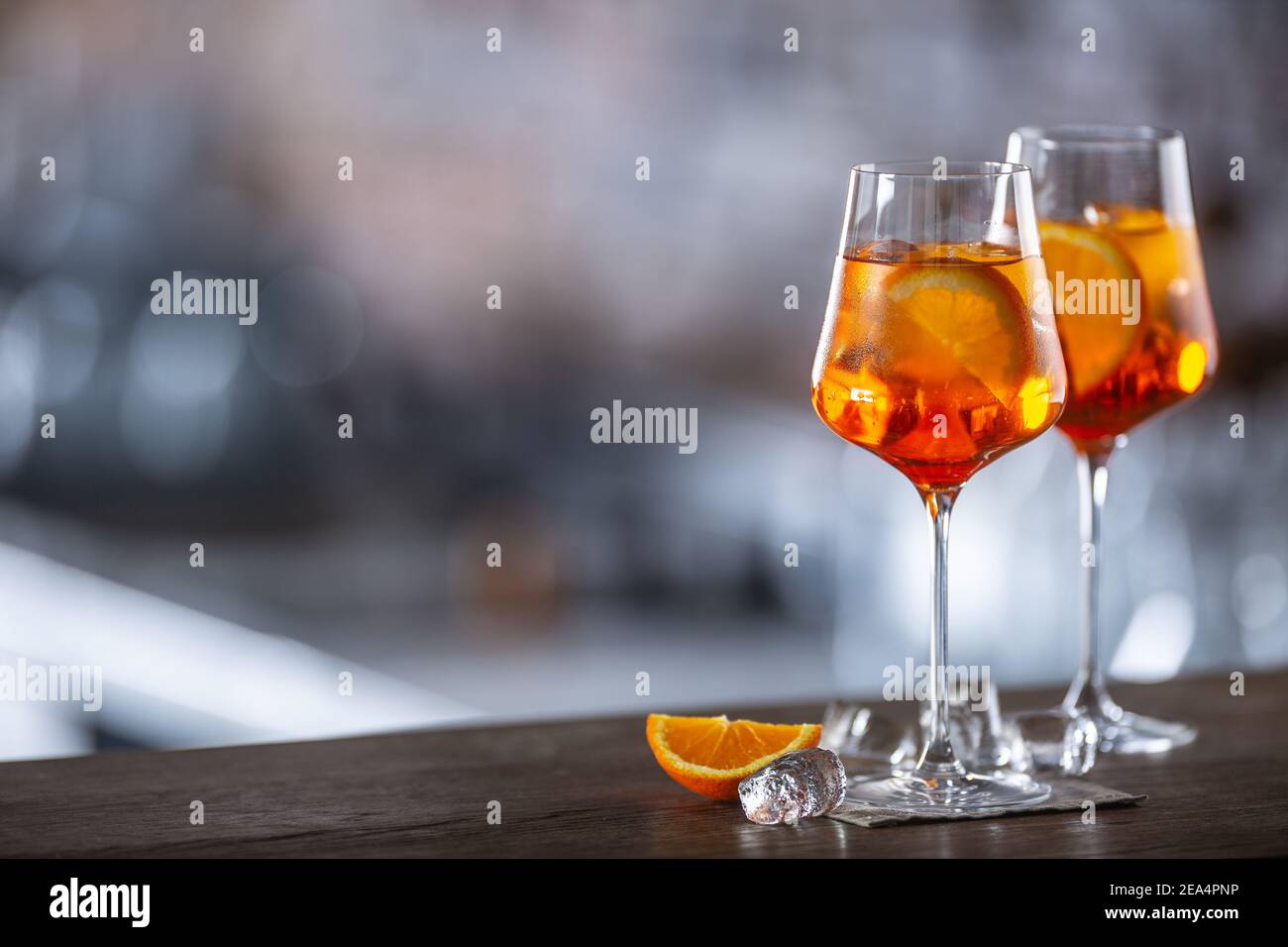 Tipica bevanda estiva aperol Spritz servita in bicchiere di vino con aperol, prosecco, soda e una fetta di arancia. Foto Stock