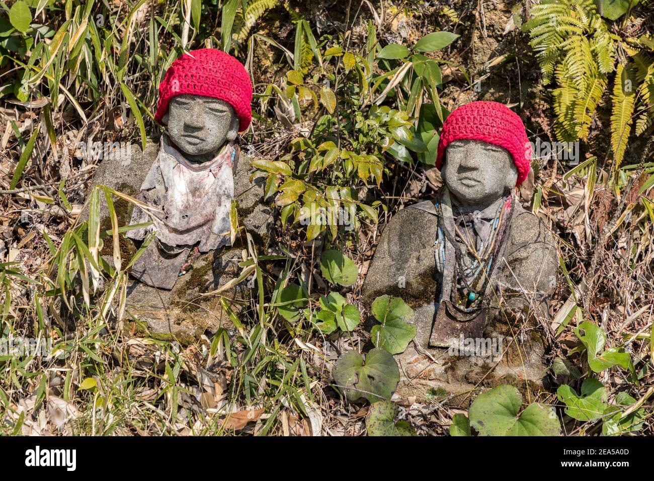 Statue di pietra con cappelli rossi, Ruriko-ji pagoda, Giappone Foto Stock