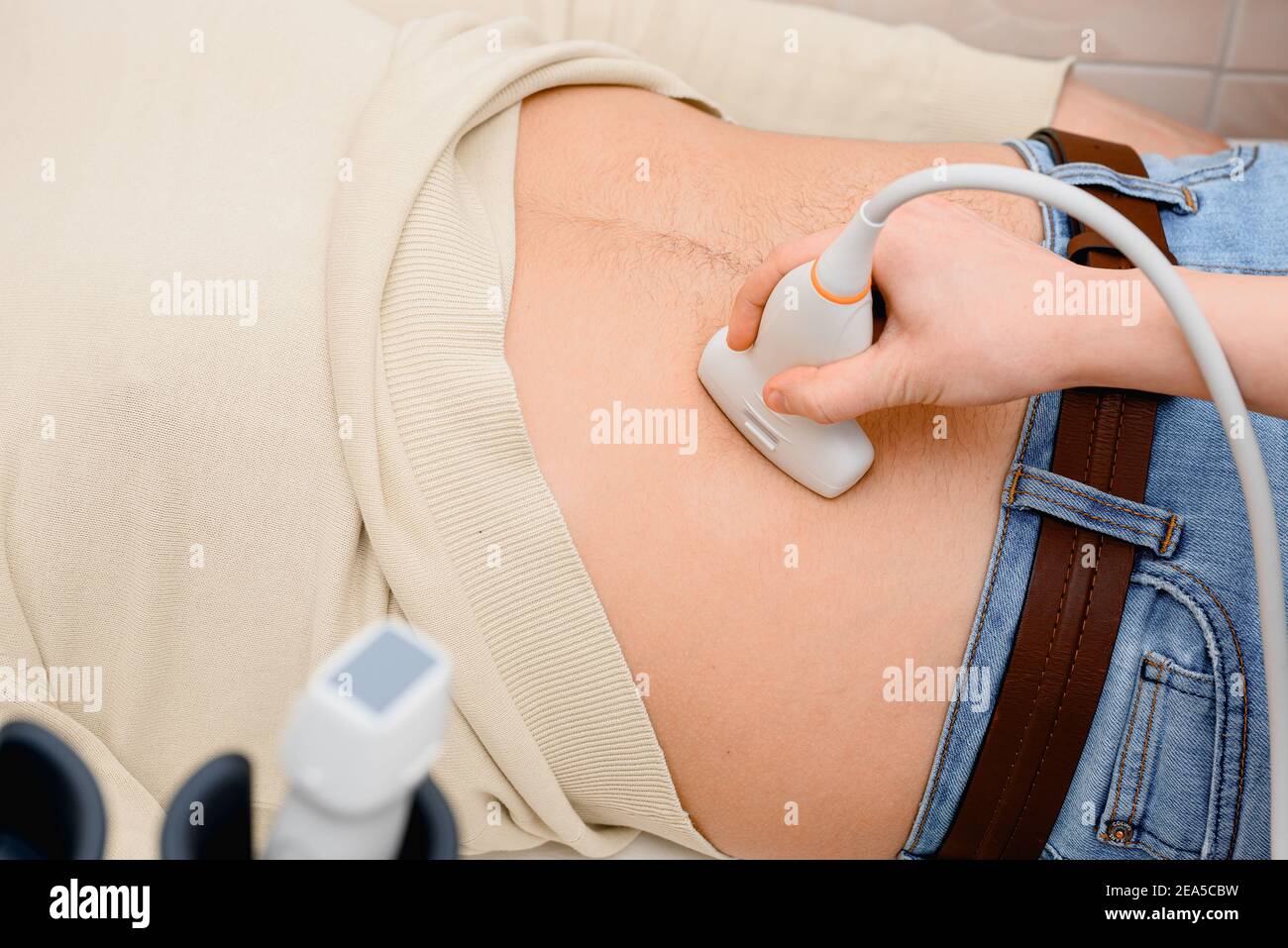 Il medico utilizza un ecografo per esaminare il corpo del paziente Foto Stock