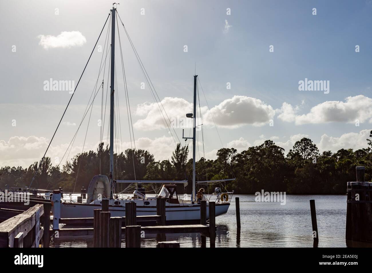 Una barca a vela ormeggia in un molo lungo il fiume St. Lucie presso il St. Lucie Lock and Dam vicino a Stuart, Florida, USA. Foto Stock