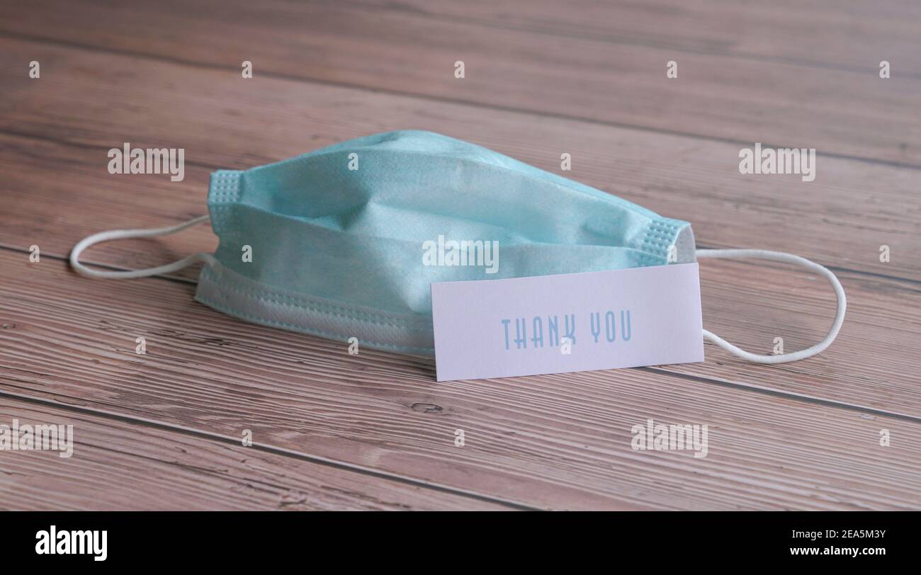Grazie nota accanto alla maschera medica viso. Apprezzamento per i frontliner e il personale medico che combattono Covid-19. Foto Stock