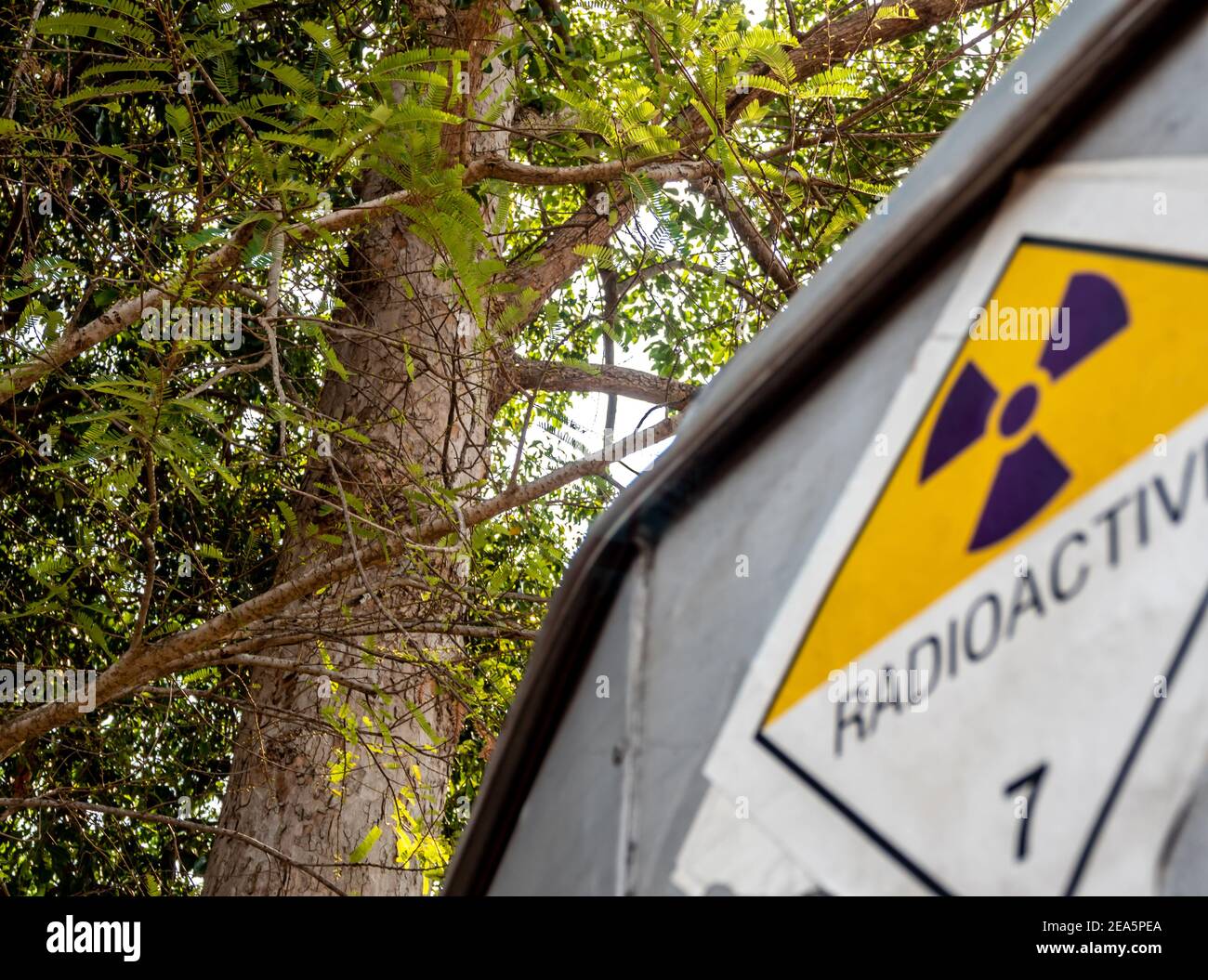Etichetta per il trasporto di radiazioni adesivo di classe 7 applicata sul vecchio adesivo sul contenitore in alluminio del carrello di trasporto Foto Stock