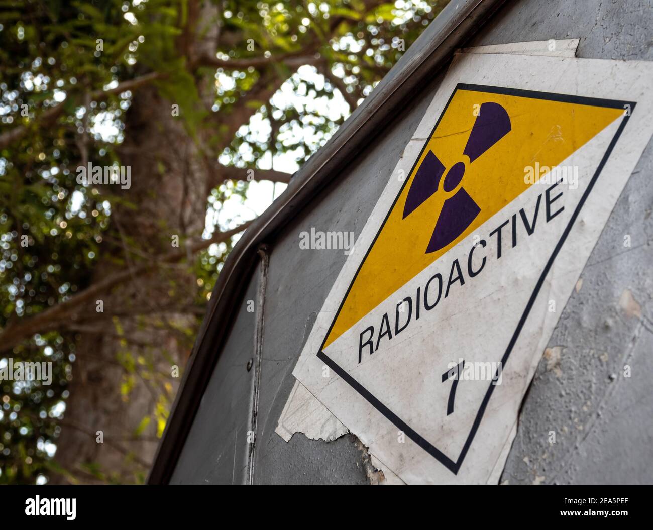 Etichetta per il trasporto di radiazioni adesivo di classe 7 applicata sul vecchio adesivo sul contenitore in alluminio del carrello di trasporto Foto Stock