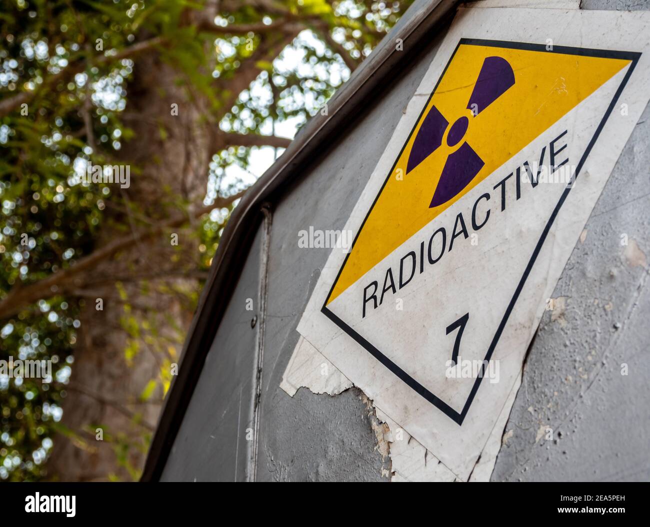 Etichetta per il trasporto di radiazioni adesivo di classe 7 applicata sul vecchio adesivo sul contenitore in alluminio del carrello di trasporto Foto Stock