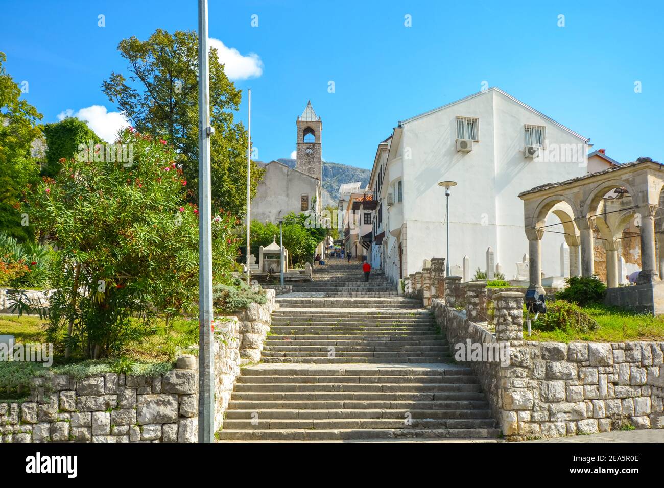 Una lunga scalinata con molti scalini passa un cimitero che conduce ad una chiesa medievale nel centro storico di Mostar, Bosnia-Erzegovina Foto Stock