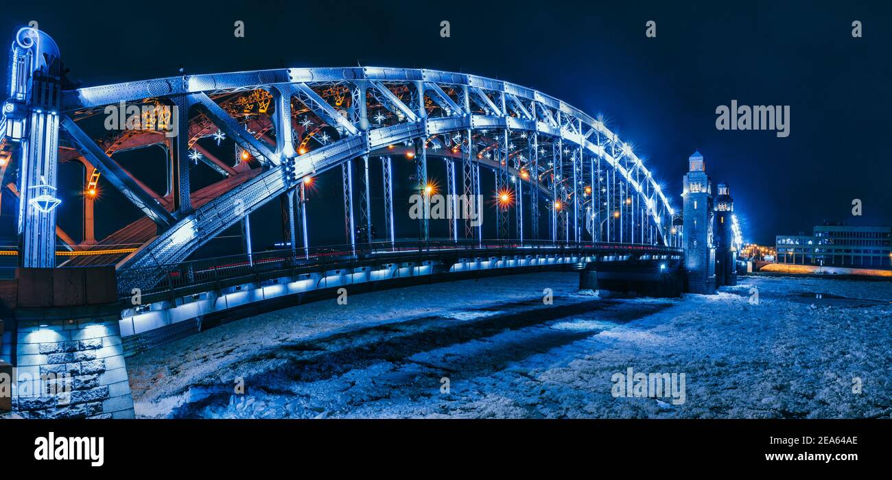 Ponte Bolsheokhtinsky attraverso il fiume Neva. San Pietroburgo in serata d'inverno. Illuminazione notturna della città Foto Stock