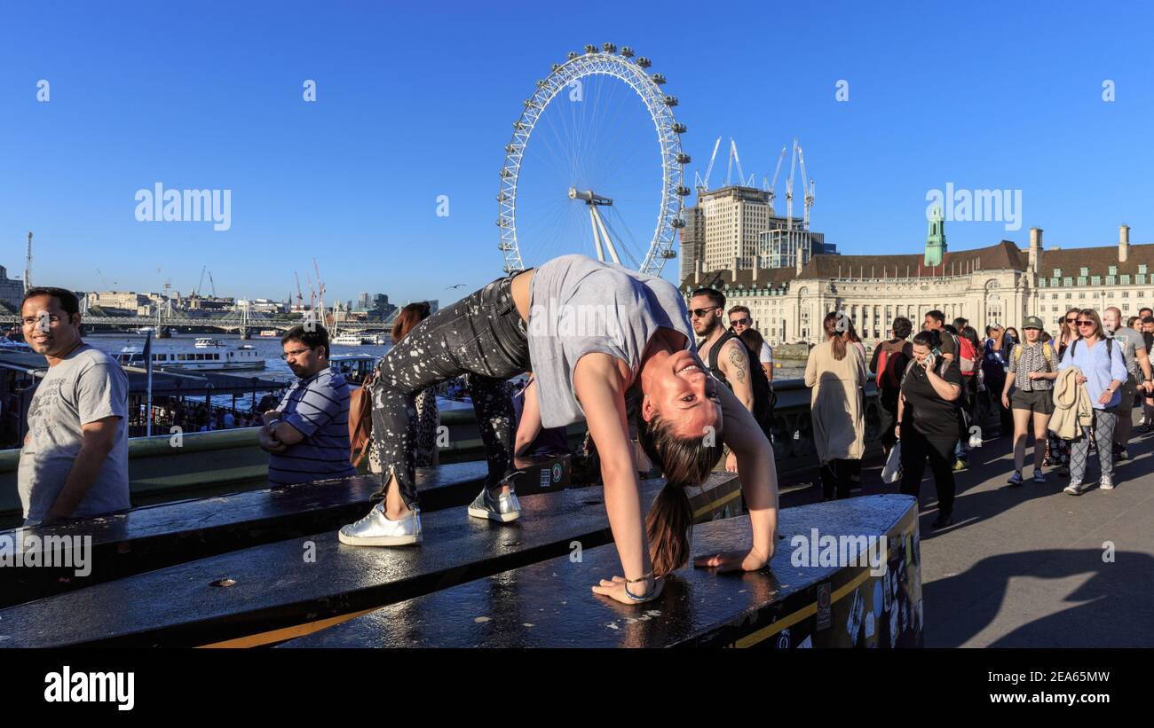 Una giovane donna si pone per un selfie con i turisti che guardano sul ponte di Westminster, Londra, Inghilterra Foto Stock
