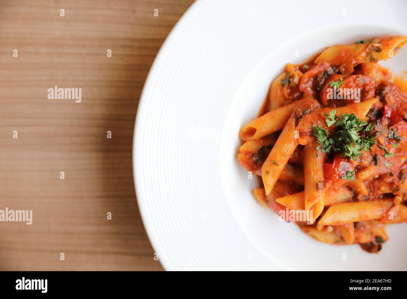 Penne arrabiata salsa di pomodoro con spezie piatti italiani legno di fondo Foto Stock