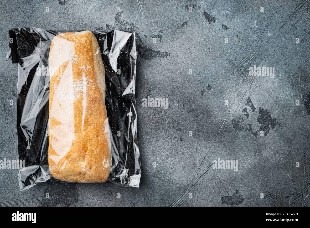 Ciabatta in sacchetto di plastica, su sfondo grigio, vista dall'alto piatto, con copyspace e spazio per il testo Foto Stock