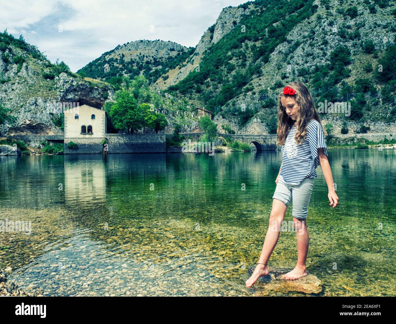 Ragazza in piedi su una roccia in Lago di San Domenico, l'Aquila, Abruzzo, Italia Foto Stock