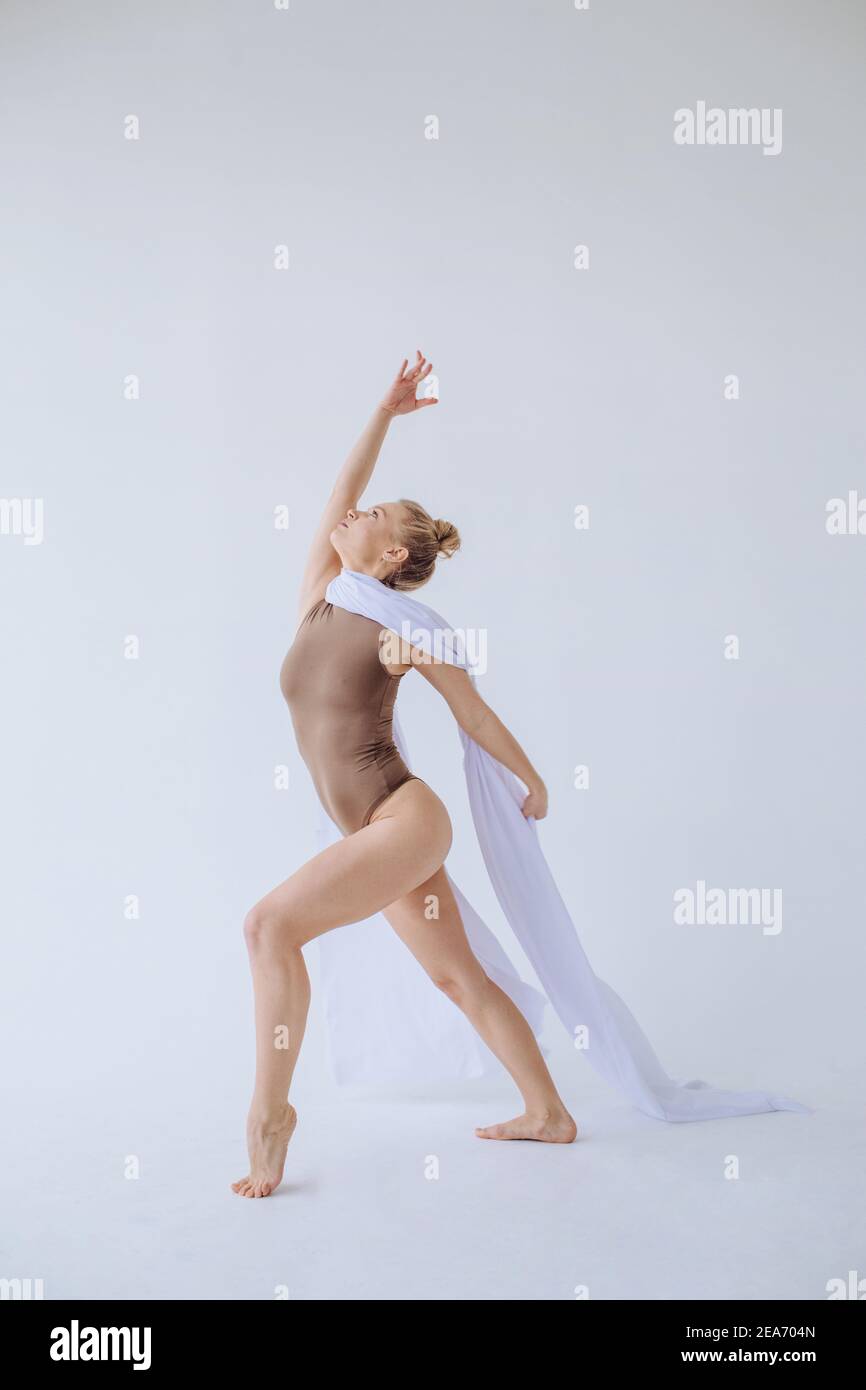 Donna che balla con tessuto bianco drappeggiato sulle spalle Foto Stock