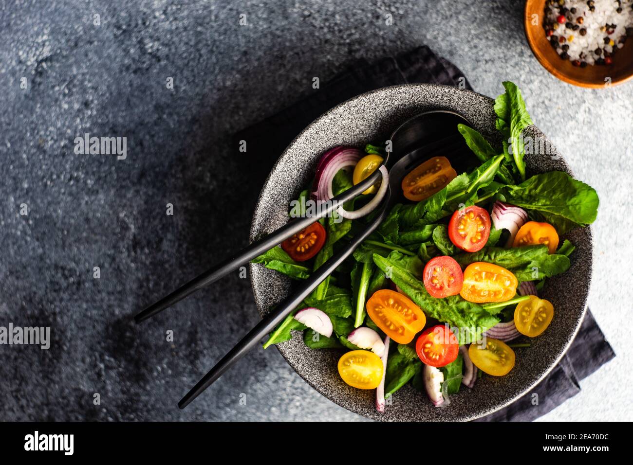 Ciotola di insalata di razzo fresca con pomodori ciliegini e rosso cipolla Foto Stock